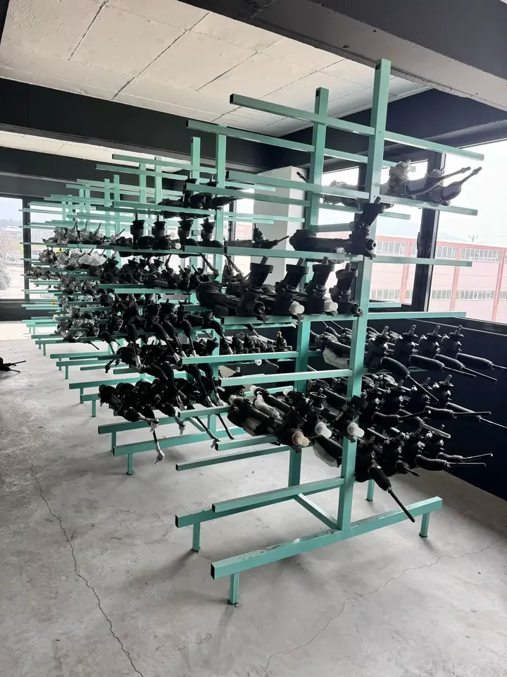 Oytun Direksiyon atölyesinde yeşil metal raflarda düzenlenmiş direksiyon kutuları
